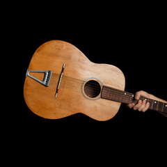 Hand holding vintage acoustic guitar on black background. Musician with folk or blues instrument,...
