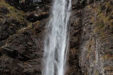 Fototapeta premium dettagli di una cascata di montagna e del flusso d'acqua che scorre e cade lungo una parete rocciosa