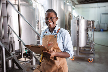 Woman brewmaster checking quality in craft beer brewery