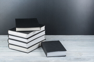 Open books on wooden table, black board background. Back to school. Education business concept.