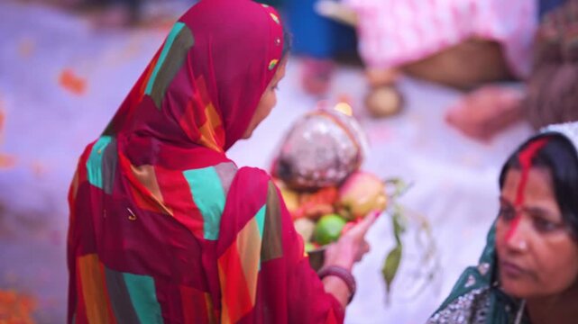 Close-up of woman offering coconut and fruits in soop during Chhath Puja sunrise ritual, representing faith and devotion.