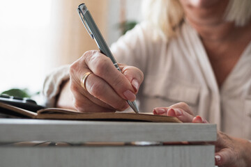 Senior woman writing in notebook or journal