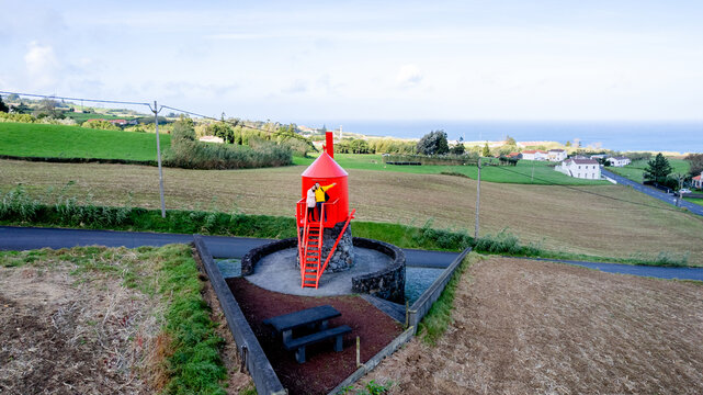 Couple at the red Moinho da Cha windmill in Salao, Faial, Azores