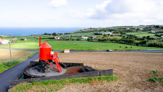 Woman at the red Moinho da Cha windmill in Salao, Faial, Azores