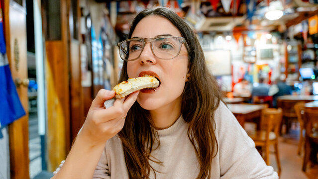 Woman enjoying garlic bread in a Portuguese restaurant