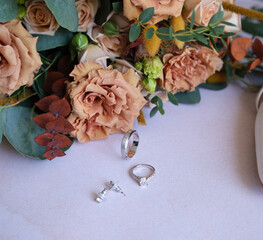 Rings, earrings, bouquet, bridal shoe