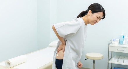 診察室で腰の痛みを訴える女性患者