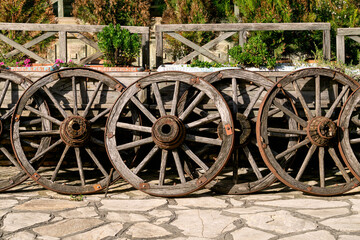 Fototapeta premium A group of old wooden wheels used as yard decoration.