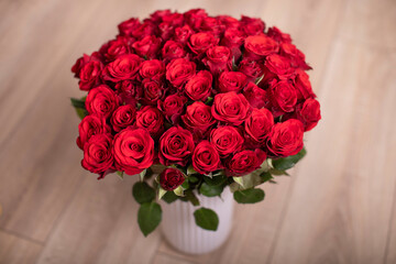 Bouquet of red roses in vase standing on the floor