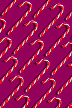 Candy canes on vibrant purple background pattern