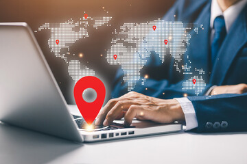 Businessman using laptop with digital world map and red location pins. Concept of global business network, international logistics, worldwide communication, and technology connection.