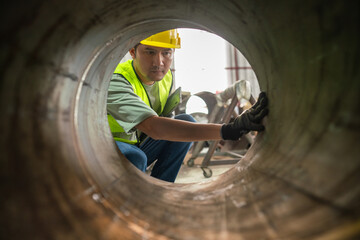 Worker inspecting industrial pipe factory environment action shot focused viewpoint safety precautions for optimal performance