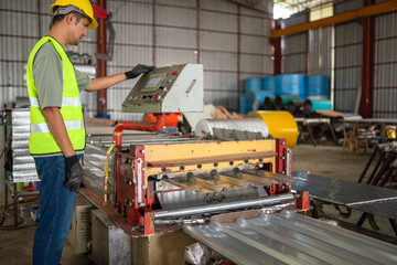 Industrial worker operating sheet metal machine manufacturing facility action shot workshop environment close-up view productivity enhancement