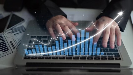 A businessperson engages in data analysis on a laptop while observing financial graphs and trends in a contemporary office setting, symbolizing growth and success. Copula - Powered by Adobe