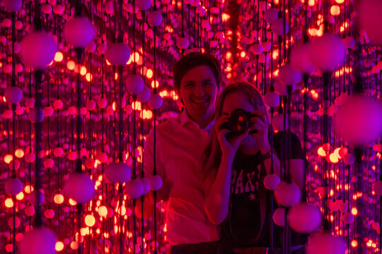 A Couple Positively Posing Together in a Vibrant Light Installation