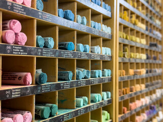 Artistic collection of colorful pastels neatly arranged in a wooden cabinet, perfect for art enthusiasts and creative projects.