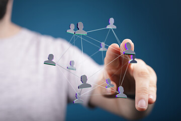 Close-up of a human hand interacting with a digital network of people. Concepts of connection, networking, communication, and community.