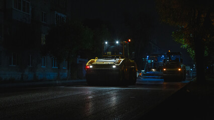 Urban scene with shadowed machinery beneath glowing streetlamp