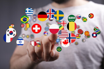 A person's finger touching various global flags, representing international relations, diversity, and teamwork. Focus on the concept of global c
