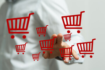 Hand reaching out to shopping cart icons, symbolizing online shopping, e-commerce, and digital retail. Illustrating the concept of online buying