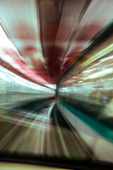 Fototapeta premium Dynamic motion blur of a Paris metro train taking a curve at high speed in a tunnel illuminated with colorful lights and flashes.
