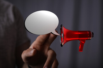 Hand holding a red megaphone with an empty speech bubble, ready for your announcement or message....