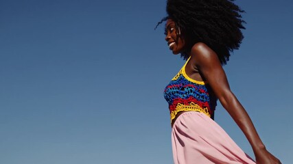 Bright summer day in the park with a joyful woman wearing a colorful outfit and enjoying the sunshine while walking