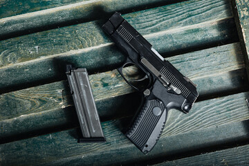 Obraz premium military firearm setup, service pistol on ammunition box, olive drab pistol resting against wooden