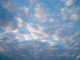 Soft stratocumulus clouds across pale blue evening sky