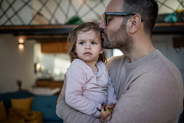 Father kissing daughter's forehead showing love and affection