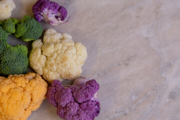 Colorful cauliflower varieties on a marble kitchen countertop