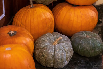 Bright orange and green pumpkins displayed in a rustic autumn setting