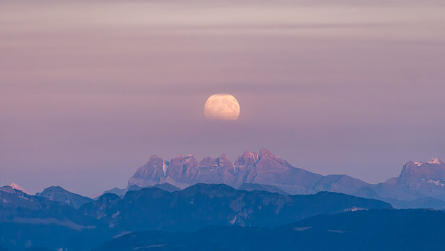 Full moon rising over Les Dents du Midi peaks in Switzerland