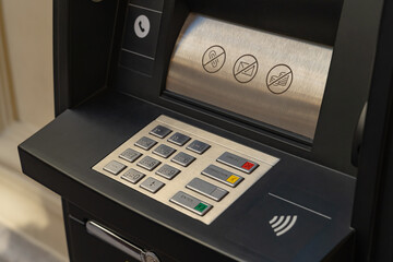 Close-up of an ATM keypad with symbols and contactless
