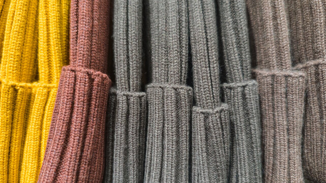 Colorful knit hats stacked in neat horizontal rows