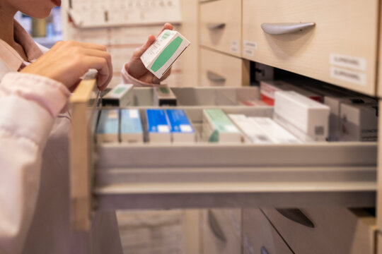 Pharmacist organizing medication in a pharmacy drawer
