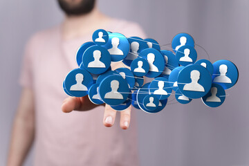 Close-up of a hand presenting a 3D rendered network of interconnected people. Illustrating social...