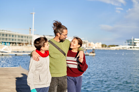 Father enjoying a sunny day at the waterfront with his children