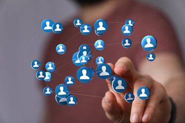 A hand interacting with a digital network of people, representing connection and community.