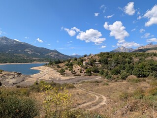 the lac de calacuccia reservoir with low water level and dry shore in sunshine