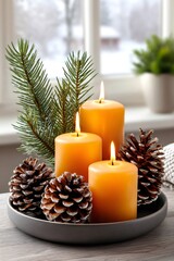 Burning candles with pinecones and evergreen branch