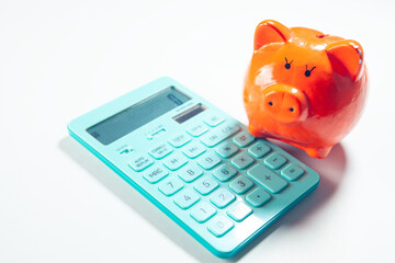 Calculator and piggy bank on white background. Saving concept