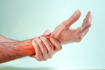 Fototapeta premium Man suffering from wrist pain, closeup of hands on light background