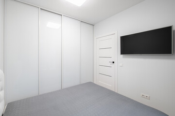 Minimalism Home Bedroom Interior. King Size Double Bed, Wardrobe, Closet. White Walls and Ceiling.