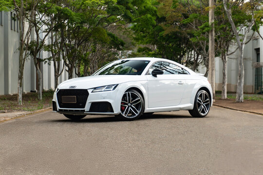 White Audi TT RS on tree-lined road, Luxury sports coupe front view three quarters