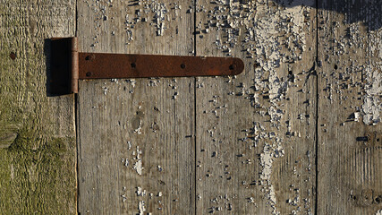 old padlock. Closeup view of an old padlock covered in rust, attached to a cracked wooden door. It represents themes of security, the passage of time, decay, and vintage aesthetics. the door is locked