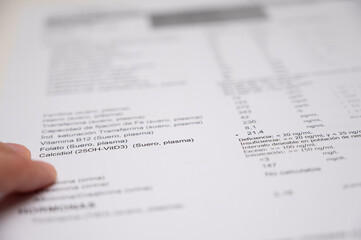 Obraz premium Hand pointing on blood test results document in Spanish