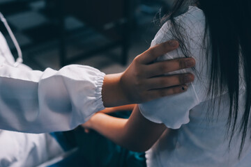 Doctor giving hope. Close up shot of young female physician leaning forward to smiling elderly lady patient holding her hand in palms. Woman caretaker in white coat supporting encouraging old person