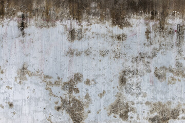 Grungy weathered concrete wall with cracks and stains, exuding a raw, aged texture background