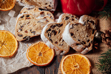 Christmas stollen on wooden background. Traditional christmas german dessert cut into pieces. Cake with nuts, raisins with marzipan and dried fruit on cutting board. baking for xmas